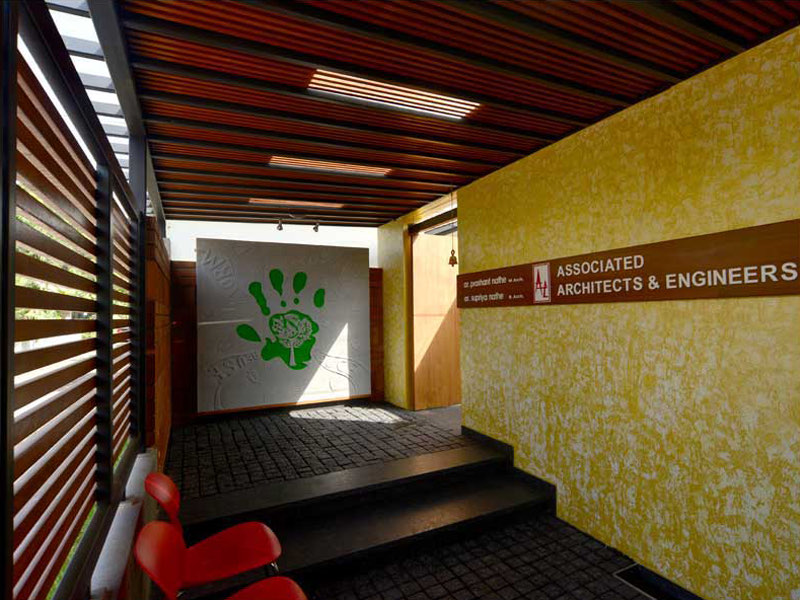 The AA&E studio — the entrance ramp and the practice name on the yellow wall